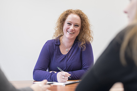 A Delta student working at a conference table. 