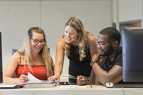 Students working with instructor in computer lab