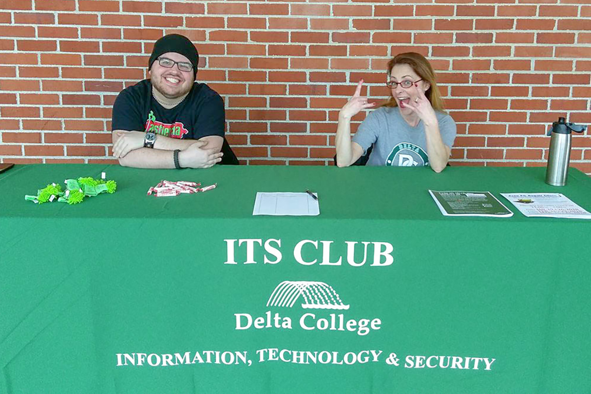 Students sitting at an ITS Club table in the hallway.