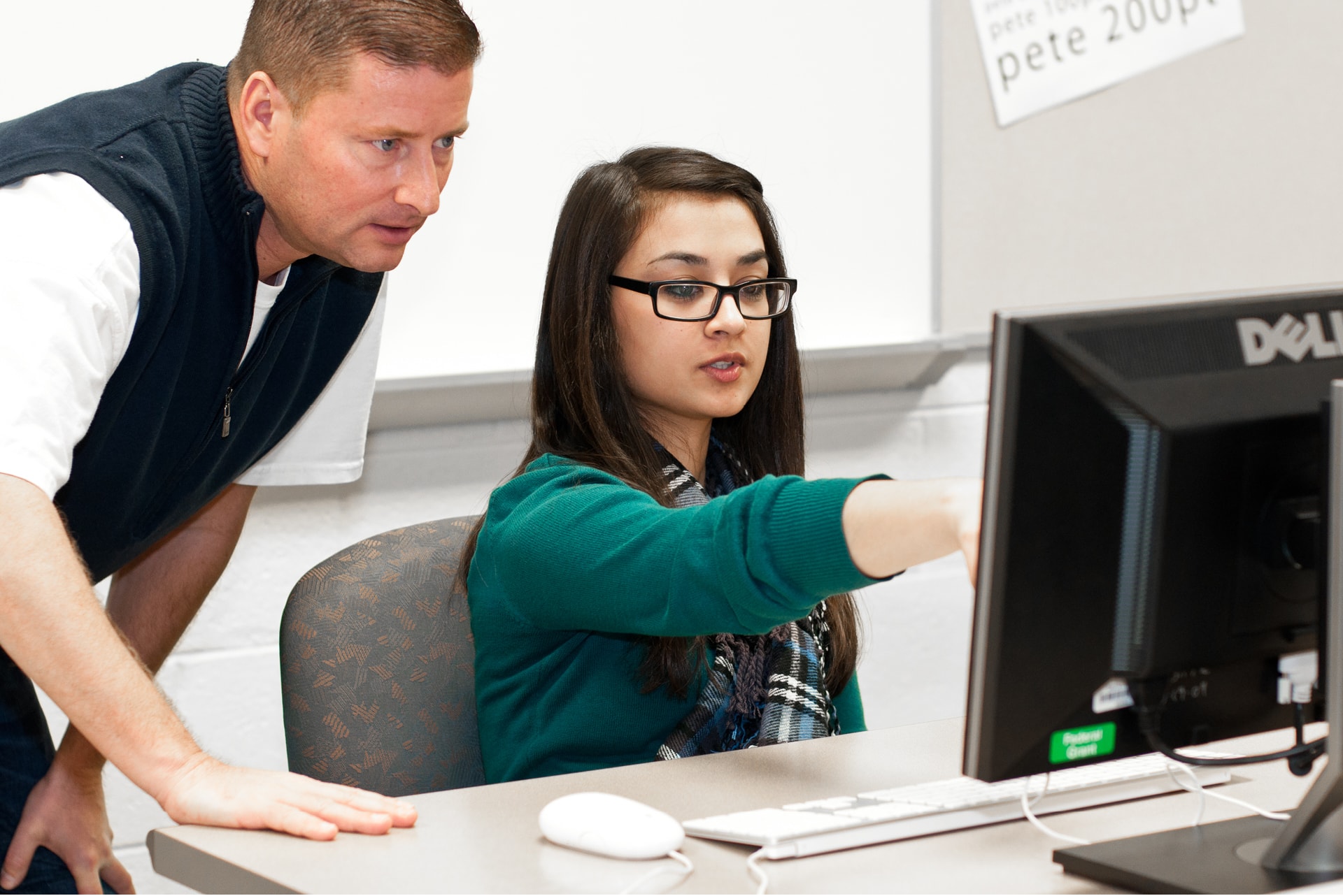 Student and teacher at computer.